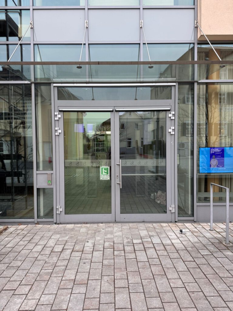 Durchsichtige Glasfrot mit Eingangstür einer Stadthalle