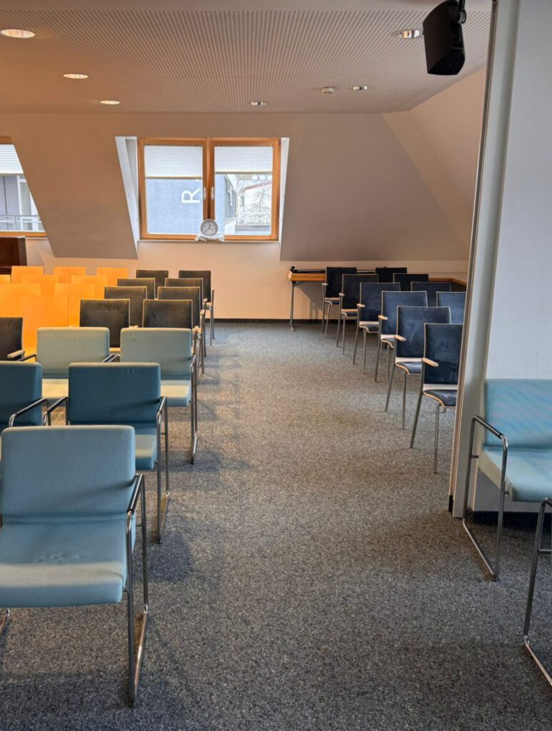 Gemeindesaal mit hellblauen Stühlen